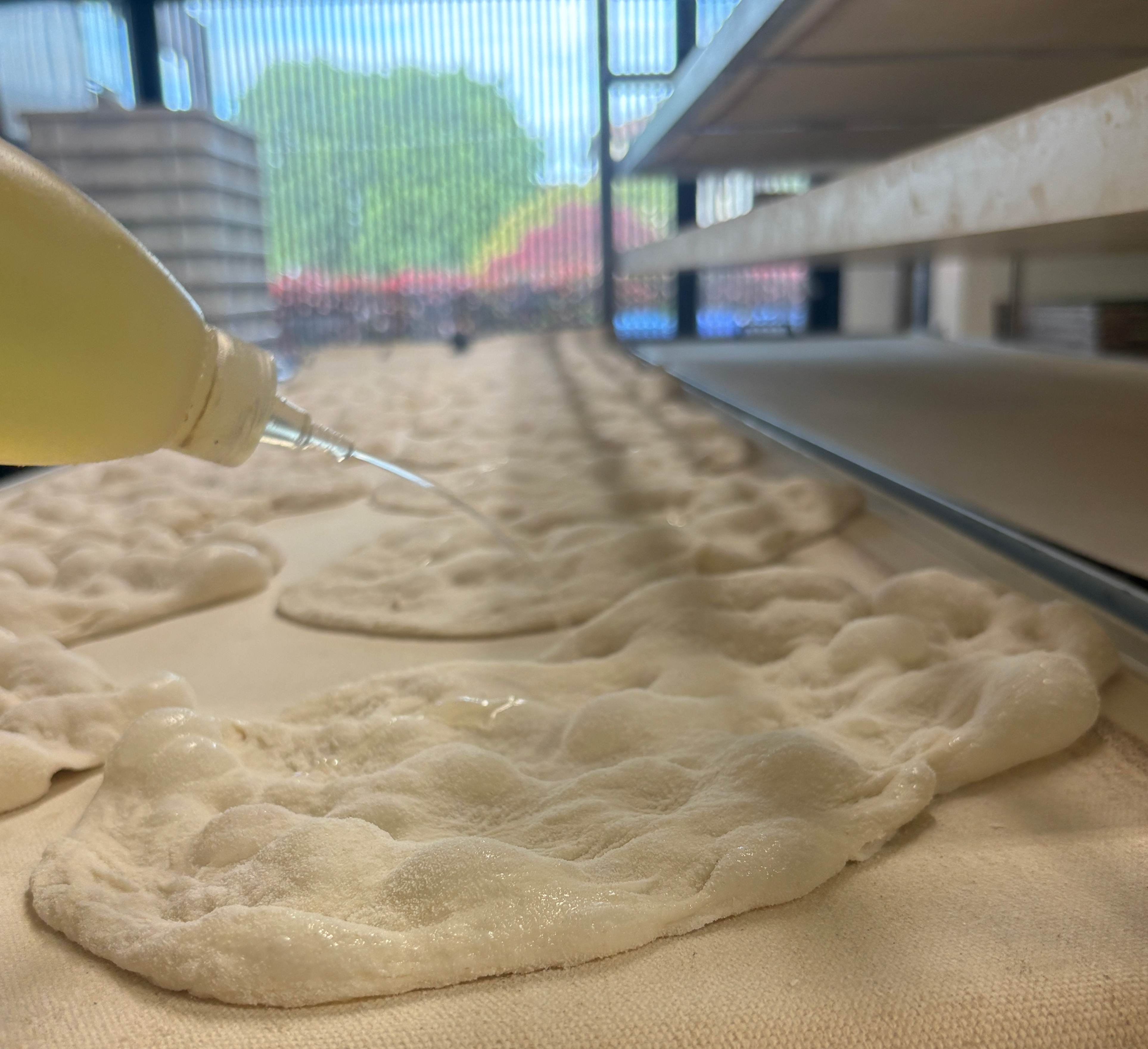 spruzzo olio su impasto pinsa